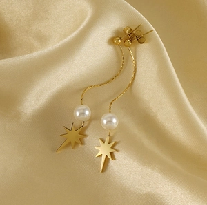 Detail of gold eight-pointed star earrings with long tassels and pearls on gold silk