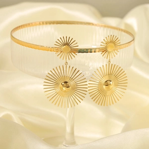18K gold plated stainless steel sunburst drop earrings on white silk and glass tray