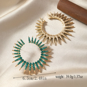 Detail view of gold sunburst hoop earrings with green rhinestones and size dimensions