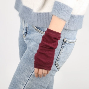 Detailed knit texture of burgundy striped arm warmers worn over a blue sweater