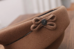 Detail of wool felt riding hat with brown bow and rhinestone embellishment