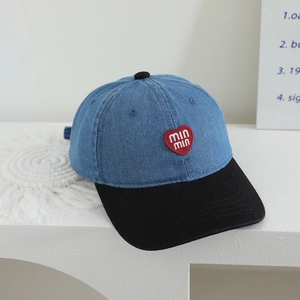 Detail of red heart embroidery and min min text on a two-tone denim kids baseball cap
