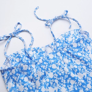 Detail of adjustable shoulder tie and blue floral print pattern on elegant dress