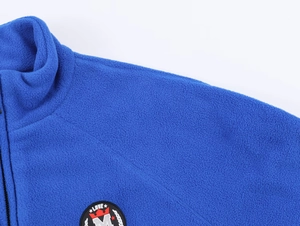 Close-up of blue soft fleece jacket with Love crown embroidery and zipper collar
