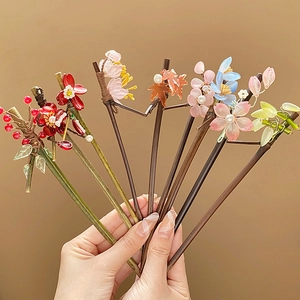 Handcrafted Chinese hair pins featuring floral resin petals, pearls, and tassels detail