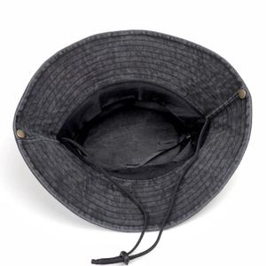 Detail view of washed cotton boonie hat showing adjustable chin cord and metal side snaps