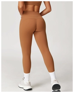 Detail der hoch taillierten Yoga-Hose in Karamell mit Push-up-Effekt und nahtloser Textur