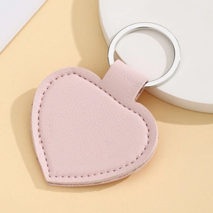 Close-up of pink heart-shaped PU leather keychain with stitching details and silver ring