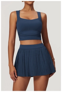 Detail of navy blue ruched sports vest and pleated skirt for tennis and yoga fitness
