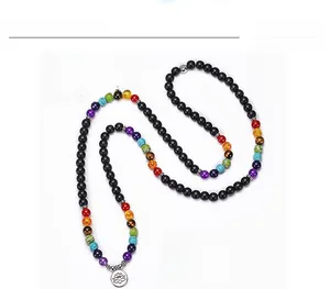 Détail macro de 108 perles noires mates avec sept pierres de chakra et pendentif lotus