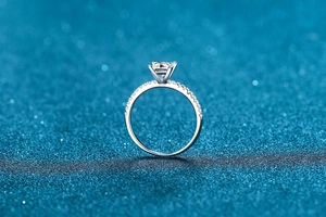 Macro shot of square-cut moissanite stone and pave side diamonds on silver ring