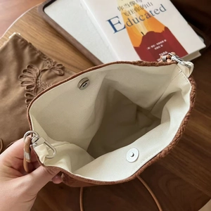Détail de l'intérieur d'un sac en daim marron avec fermoir magnétique et doublure