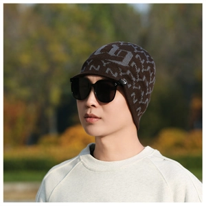 Close-up of brown knit beanie featuring grey NY jacquard pattern and short brim design