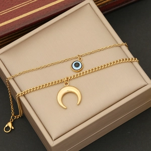 Close-up of double-layered gold stainless steel necklace with evil eye and crescent moon