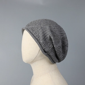 Close-up of grey hollow knit bucket hat showing intricate wave pattern and breathable texture