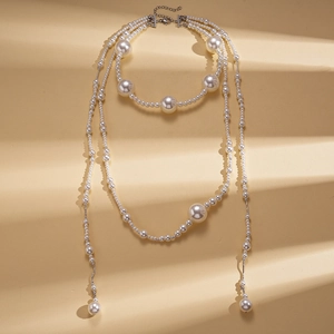 Collier de perles baroques multicouches avec détails argentés sur fond minimaliste