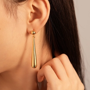 Close-up of elegant gold teardrop earrings worn by model showing style and scale