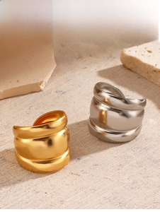Chunky wave textured open rings in gold and silver finish on rustic wooden surface