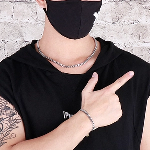 Silver Cuban chain necklace and bracelet set for men on model with urban gray background