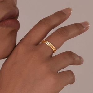 Close-up of three-piece gold-plated stainless steel rings with zircon on model's hand