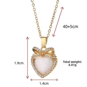 Macro detail of gold titanium heart necklace with cat eye stone and 1.9x1.4cm dimensions