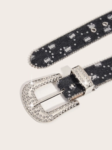 Close-up of black denim belt featuring sparkling silver rhinestone buckle and eyelet details
