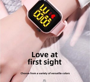 Macro shot of a pink silicone strap digital watch with a glowing LED square display