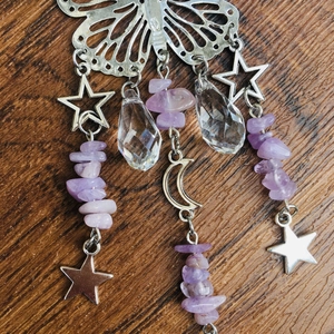 Detail of silver butterfly suncatcher with crystal beads and moon charms on wood