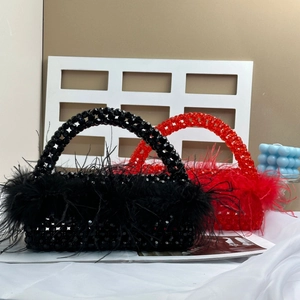 Macro detail of handmade beaded evening bags featuring elegant ostrich feather trim