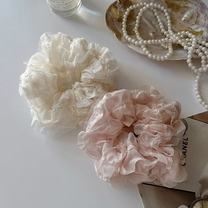 Coleteros de encaje en crema y rosa sobre escritorio con estilo minimalista