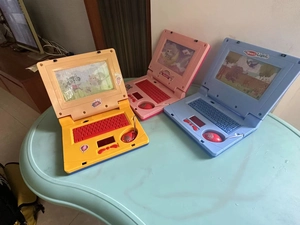 Detailed comparison of electronic learning toy laptops in red, yellow, and blue colors