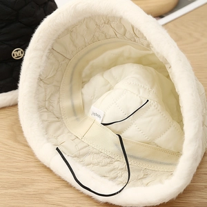 Detail of winter faux fur bucket hat showing quilted lining and adjustable cord