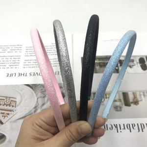 Sparkly glitter headbands in pink silver black and blue displayed against a magazine background