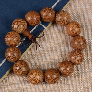 Bracelet de prière en bois de wengé avec grain naturel brun sur fond de papier bleu