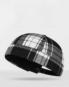 Close-up of black and white checkered docker hat with metal eyelet detail and woven texture