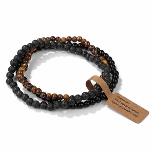 Detail view of 4mm natural tiger eye and lava stone stretch bracelets with paper tags