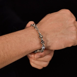 Detailed view of men's stainless steel beaded bracelet on wrist with grey marble beads