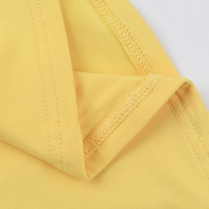 Close-up of yellow knit fabric stitching and double-needle hem on a slim-fit crop top