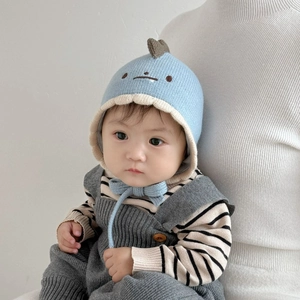 Close-up of cute embroidered baby knit hat and matching jumpsuit on infant model