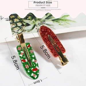 Detail view of 5.8cm glitter Christmas hair clips with candy and sock patterns