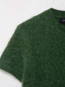 Primo piano del maglione in maglia mohair verde scuro con texture soffice e scollo rotondo
