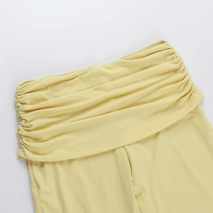 Dettaglio dell'ampia fascia arricciata in vita sui leggings yoga giallo chiaro