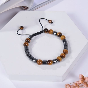 Detail view of adjustable tiger eye and hematite beaded bracelet on a white display