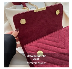 Close-up of burgundy quilted suede bag with gold magnetic snaps and chain strap