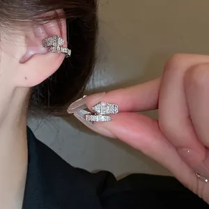 Silver snake-shaped C-style ear cuff with sparkling zircons worn on the upper cartilage