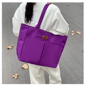 Detailed view of a purple nylon tote bag with double front pockets and large capacity
