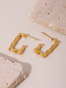 Detailed view of U-shaped bamboo textured earrings in 18K gold plated stainless steel