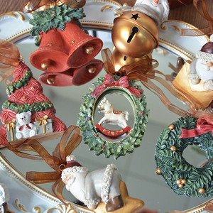 Vintage resin Christmas tree ornaments set with bells and wreaths on a mirror tray