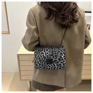 Détail du sac bandoulière léopard avec chaîne en métal et fermoir noir mat élégant