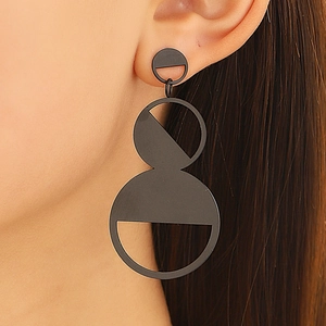 Dramatic matte black geometric drop earrings with hollow round design on a model